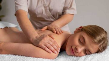 Frau lässt sich eine Rücken- und Nackenmassage geben, um Verspannungen und Stress zu lösen