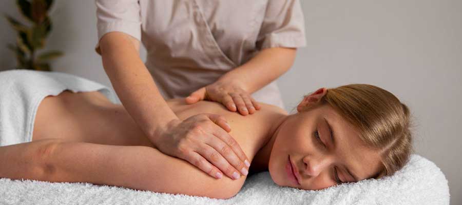 Frau lässt sich eine Rücken- und Nackenmassage geben, um Verspannungen und Stress zu lösen